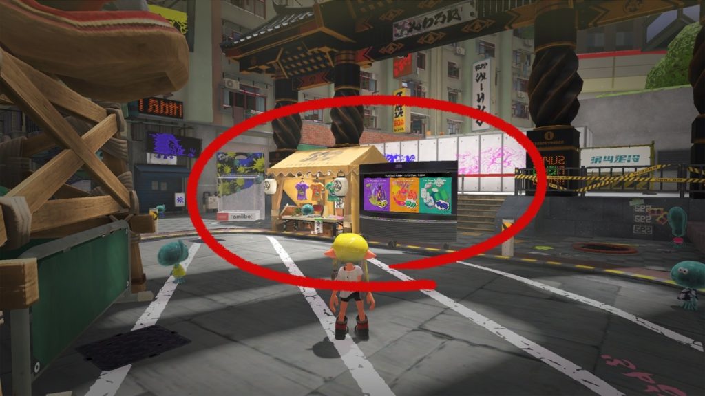 a young person with yellow hair in a torn white t-shirt stands in a metropolitan square. ahead of them is a small stand with a sign out front with purple, orange, and green posters on it. The stand is circled in red