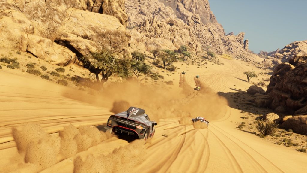 Multiple cars racing in a rocky desert valley