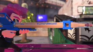 a pink haired squid kid in profile holding a long-barreled gun. the ground is covered in pink ink and there's a tree and some railings behind him