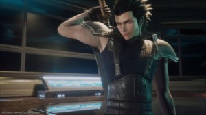 Zack Fair, a young man in a dark, tight-fitting tank top with armor shoulder guards, stands in a building lobby. He's grabbing the hilt of a sword on his back with his right arm and staring intently off screen to the left